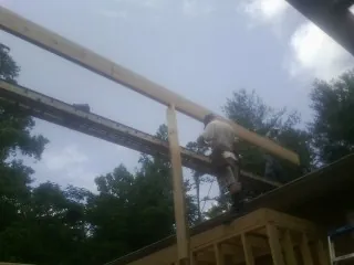Carpenter setting a ridge beam over a new addition frame — Ice Dam Removal by Roofing Brothers in San Angelo