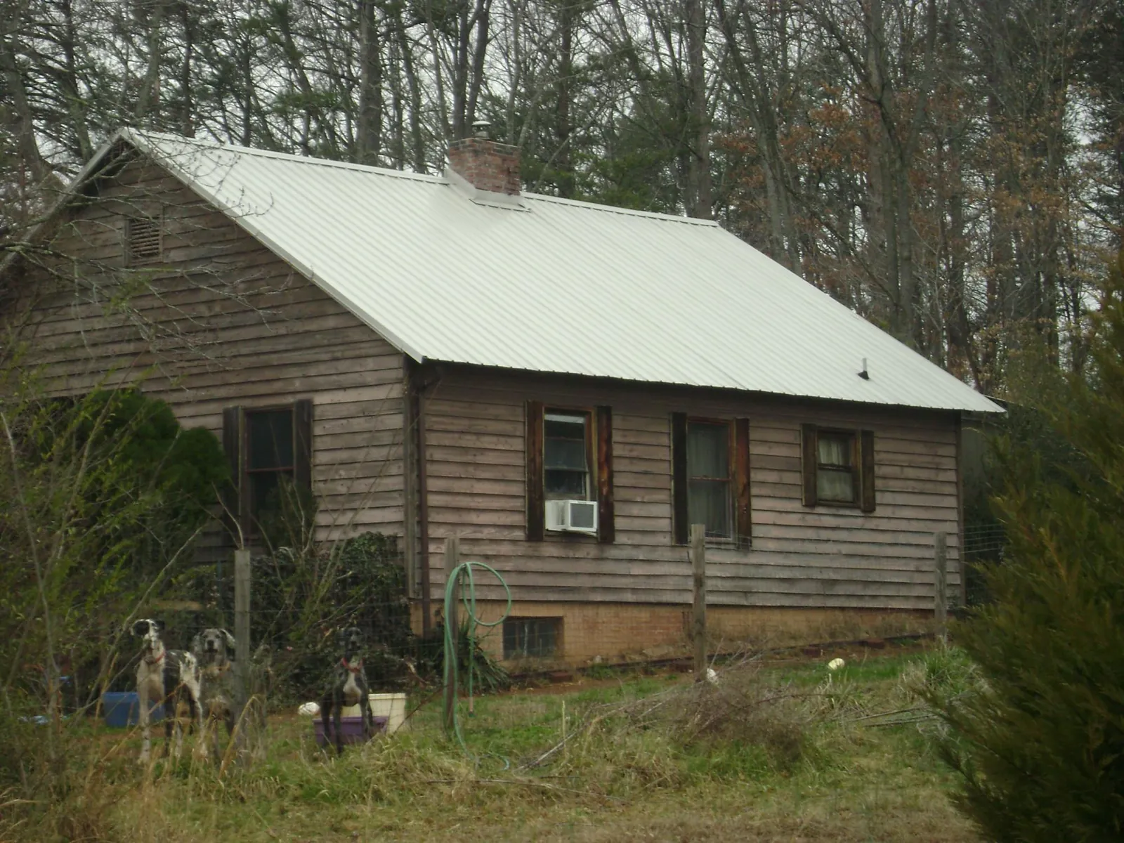 White metal roof on an old wood sided farmhouse, from a Metal Roof Installation job in San Angelo